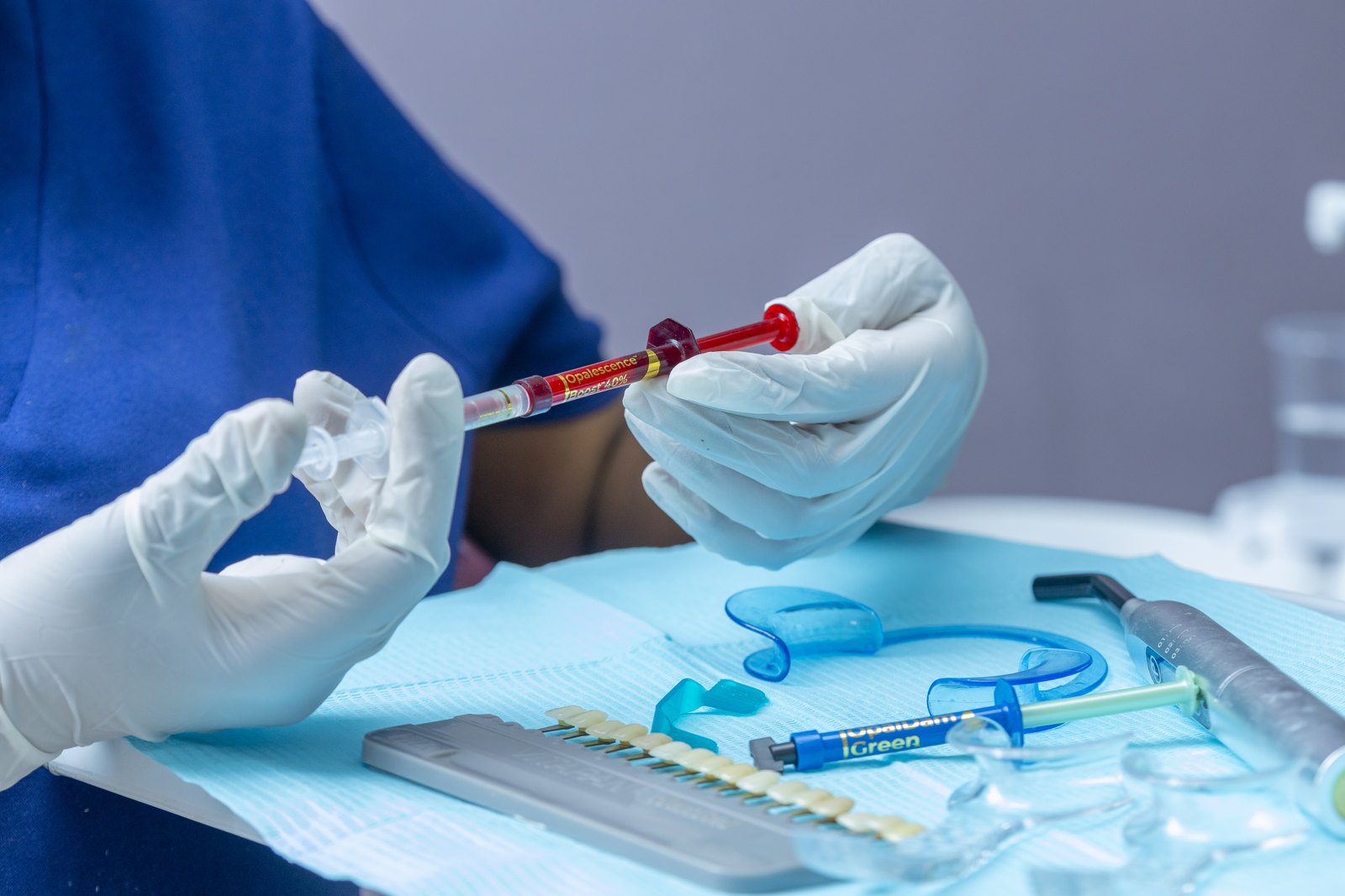 Dentiste ganté préparant une seringue de gel de blanchiment