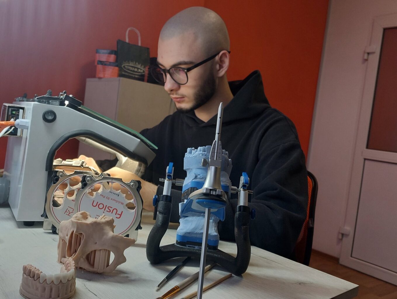 Diş laboratuvarında artikülatör başında çalışan diş teknisyeni